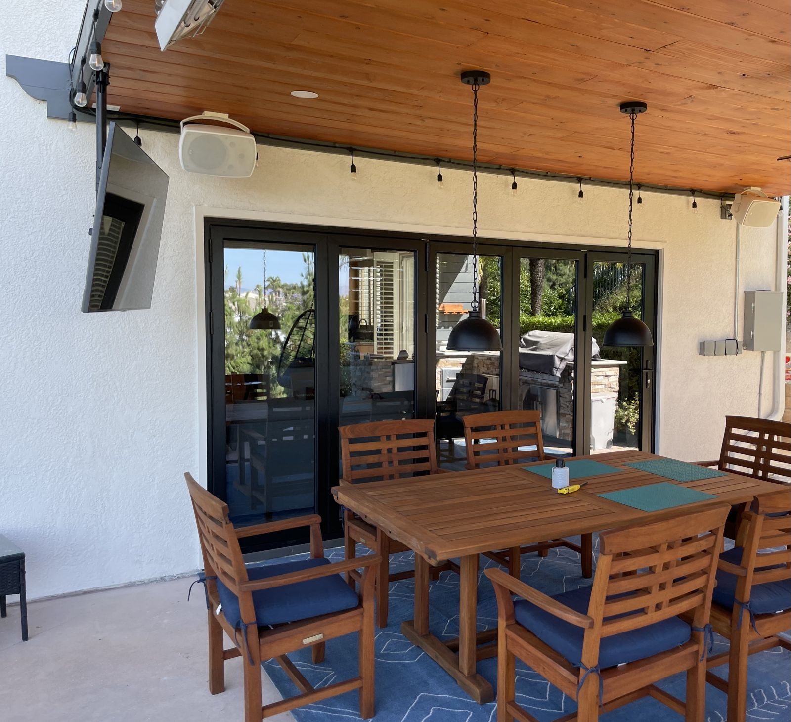 Finished covered patio with tongue-and-groove ceiling and folding glass doors